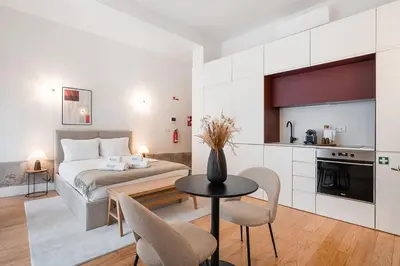 a bedroom with a bed and a table with chairs at GuestReady - Joy Apartments in Porto