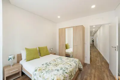 a bedroom with a large white bed with green pillows at VIVA Spacious Apartment Campanhã in Porto