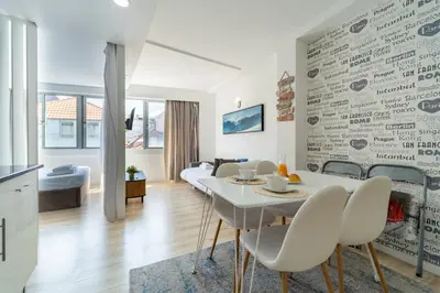 a kitchen and living room with a white table and chairs at Happy's Apartments in Porto