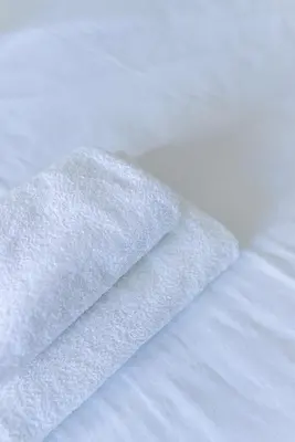 a white towel laying on top of a bed at Happy's Apartments in Porto