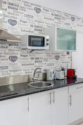 a kitchen with a sink and a wall with words on it at Happy's Apartments in Porto