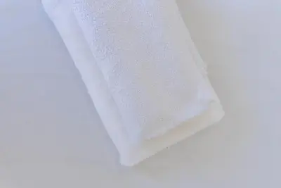 a roll of white towels sitting on a white surface at Happy's Apartments in Porto