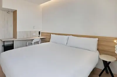 a bedroom with a large white bed and a desk at B&B HOTEL Porto Centro Massarelos in Porto