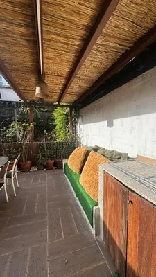 acovered patio with a bed on the side of a building at Apartamento Fontinha in Porto
