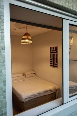 a small room with a bed and a window at Amy's Place in Porto