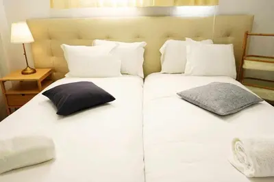 two beds with white sheets and pillows in a room at Ryamen Inn B in Porto