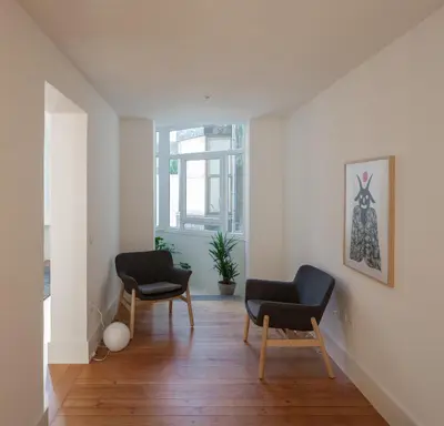 a living room with two chairs and a window at Santa Catarina 555 T4 in Porto