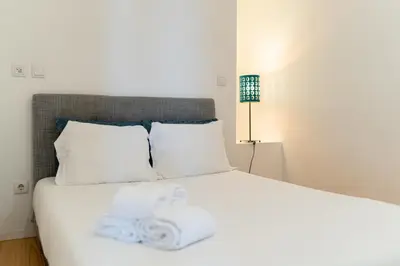 a bedroom with a bed with white sheets and pillows at Groovy Porto by Upperground in Porto