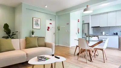 a living room with a glass table and white chairs at Green House Apartamento Espaçoso e Central in Porto