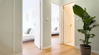 a hallway with a mirror and a potted plant at Green House Apartamento Espaçoso e Central in Porto