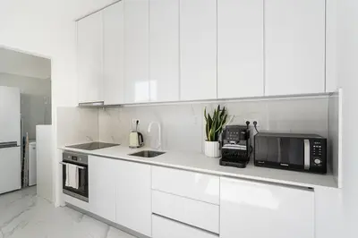 a white kitchen with a sink and a microwave at Terraced Apartment in the Heart of Porto - Free Parking in Porto