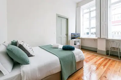 a bedroom with a bed with a green blanket on it at Porto Inlapa Studio RC in Porto