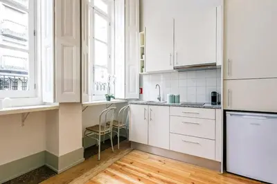 a white kitchen with white cabinets and windows at Porto Inlapa Studio RC in Porto