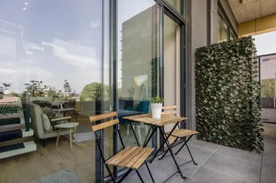 a patio with a table and chairs and windows at Douro Tower Loft - Shared Pool in Vila Nova de Gaia