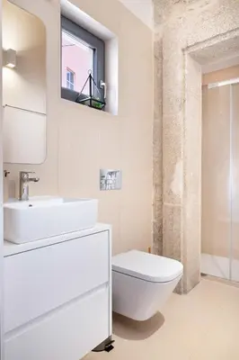 a white bathroom with a toilet and a sink at Private Terrace at Flores Street in Porto