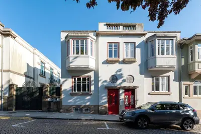 a car parked in front of a white building at Bonfim 241 Family House in Porto