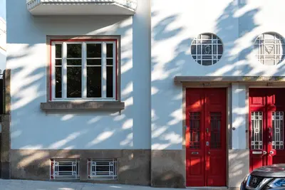 two red doors on the side of a white building at Bonfim 241 Family House in Porto