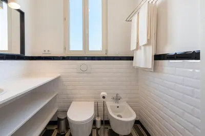 a white bathroom with a toilet and a sink at Bonfim 241 Family House in Porto