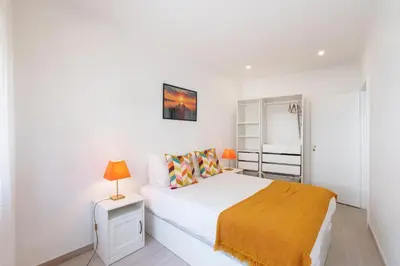 a white bedroom with a bed with a yellow blanket at VIVA Elias Sunset Apartment Gaia in Vila Nova de Gaia