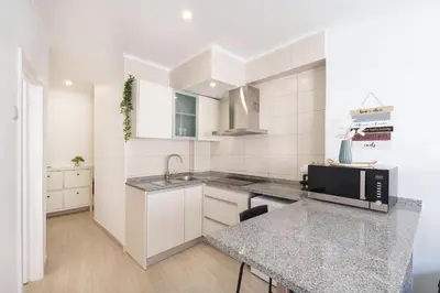 a kitchen and living room with a counter and a table at VIVA Elias Sunset Apartment Gaia in Vila Nova de Gaia