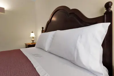 a bed with a wooden headboard and white pillows at Vintage Copio Apartment in Vila Nova de Gaia