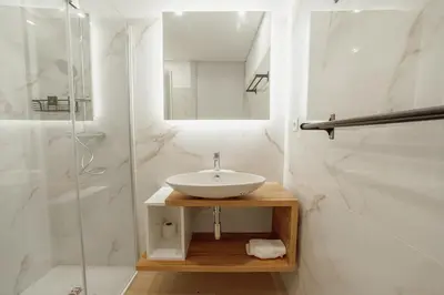 a white bathroom with a sink and a shower at Downtown Gold Bolhao by Vacationy in Porto