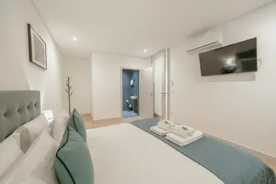 a bedroom with a large bed with a tv on the wall at Downtown Gold Bolhao by Vacationy in Porto