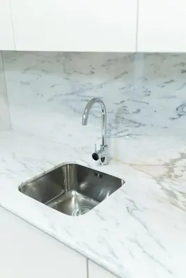 a kitchen sink in a white marble counter top at Lifestyle at Porto by Upperground in Porto