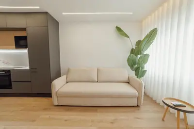 a white couch in a living room with a plant at Downtown Premium With Balcony by Vacationy in Porto