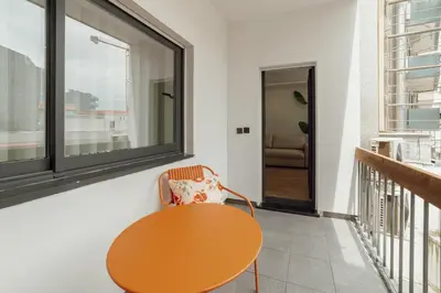 a table and a chair in a room with a window at Downtown Premium With Balcony by Vacationy in Porto