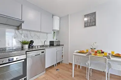 a kitchen with white cabinets and a table with fruits on it at The Porto Way in Porto