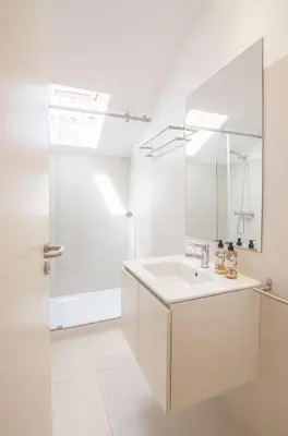 a white bathroom with a sink and a mirror at Almada 151 - 3T in Porto