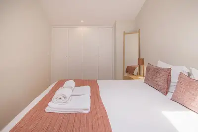 a bedroom with a white bed with towels on it at Almada 151 - 3T in Porto