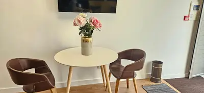 a vase of flowers sitting on a table with chairs at Serendipity in Porto
