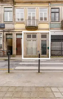 a yellow building with a balcony on a street at Serendipity in Porto