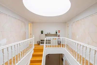 a white staircase in a white room with a ceiling at Typical Oporto House in Porto