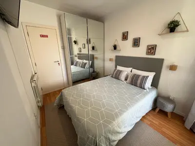 a small bedroom with a bed and a mirror at Typical Oporto House in Porto
