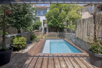 a swimming pool in a yard with a wooden deck at 58 House in Porto