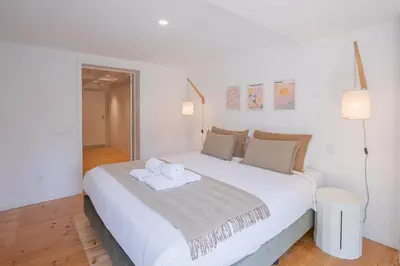 a white bed with two towels on top of it at 58 House in Porto