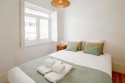 a bedroom with a large white bed with towels on it at 58 House in Porto