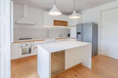 a kitchen with white cabinets and a white counter top at 58 House in Porto