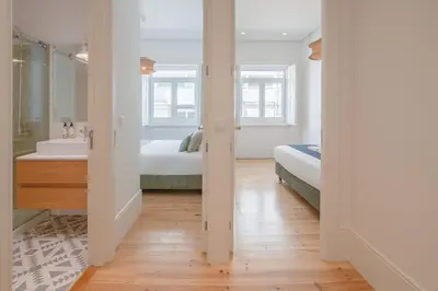 a bathroom with two beds and a sink and a mirror at 58 House in Porto