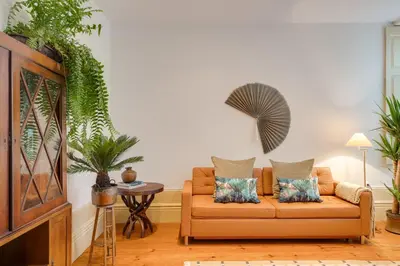 a living room with a couch and some plants at Cedofeita Vintage House DA'Home in Porto