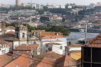 a view of a city with roofs and a river at Superb Flat w Balcony and AC by LovelyStay in Porto