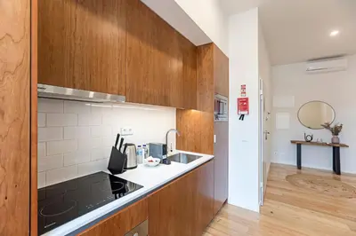 a kitchen with wooden cabinets and a sink at Superb Flat w Balcony and AC by LovelyStay in Porto