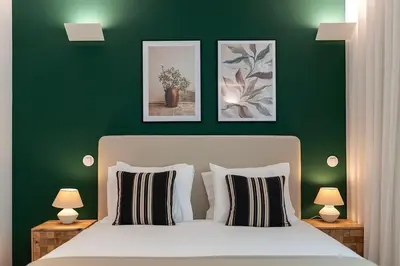 a green bedroom with a bed and two pictures on the wall at Scenic River-View T1 by Lisbeyond in Vila Nova de Gaia