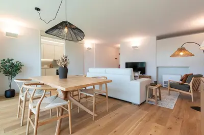 a dining room and living room with a table and chairs at Scenic River-View T1 by Lisbeyond in Vila Nova de Gaia