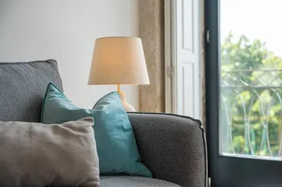 a lamp sitting on top of a couch with pillows at GuestReady - Explore Porto from a prime location in Porto