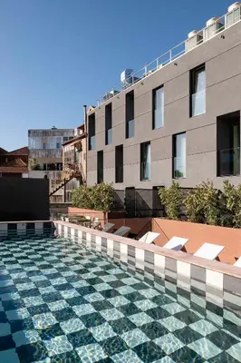 a swimming pool with a tile floor in front of a building at Artcore Hotel Porto in Porto