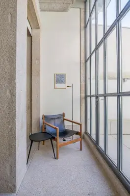 a chair and a table in a room with windows at Almada 151 - 1T in Porto